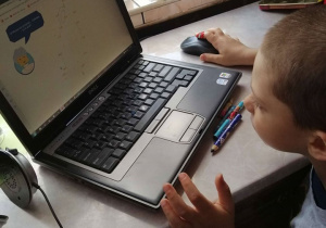 Chłopiec pracuje na komputerze.