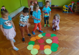 Dzieci układają obrazek z dużych, kolorowych kół.