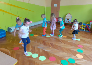 Dzieci skaczą po ścieżce z kolorowych kół.
