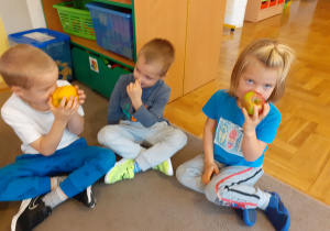 Trzech chłopców wącha owoce i warzywa.