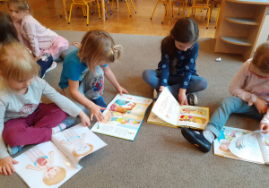 Dzieci oglądają książki o ciele człowieka.