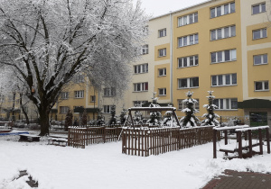 Ogrodowy sprzęt do zabawy dla dzieci pokryty warstwą śniegu.