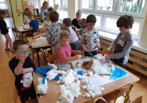 Dzieci przy stolikach przygotowują makiety lodowców.