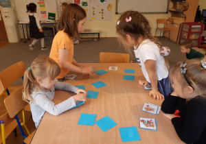 Cztery dziewczynki grają w memory z misiami.
