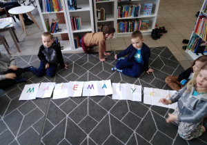 Dzieci ułożyły z kartek z literami napis "matematyka".