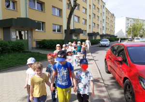 Grupa przedszkolaków idzie na spacer.