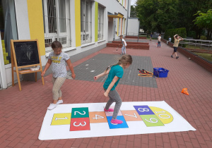 Dziewczynki grają w wielkoformatowe klasy na tarasie.