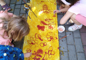 Dzieci malują kwiaty patyczkami higienicznymi.