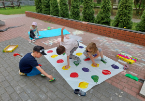 Dzieci grają w wielkoformatową grę "Wygibajtus owoce".