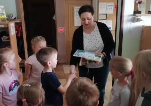 Pani dyrektor wręcza chłopcu nagrodę i dyplom.