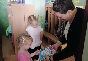 Pani dyrektor wręcza dziewczynce nagrodę i dyplom.