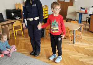 Policjantka trzyma za rękę chłopca.