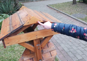 Dziecko wskazuje trójkątny element daszku karmnika dla ptaków.