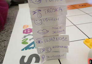 Wieża z napisów: współpraca, troska, pomoc, uśmiech, miłe słowa, uważność, rozmowa, słuchanie umieszczonych na klockach.