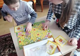 Chłopiec i dziewczynka grają w grę planszową.
