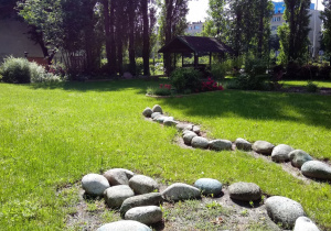 Strefa aktywności ruchowej w ogrodzie przedszkolnym - ścieżka z kamieni.
